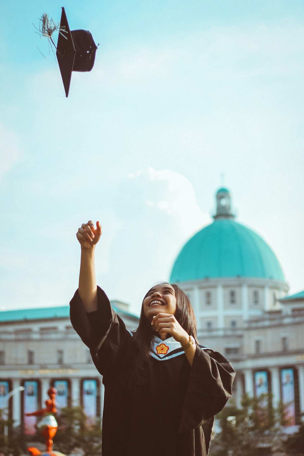 Student celebrating graduation after funding studies with an education loan for study abroad